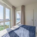 Schlafzimmer mit Blick aufs Meer und Balkonzugang.