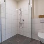 Badezimmer mit Dusche, Toilette und Waschbecken.