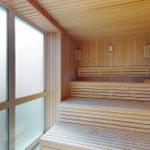 Sauna mit Holzbanken und großen Fenstern.