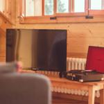 Ein Fernseher und eine Plattenspieler stehen auf einem Holztisch in einem Raum mit Holzwänden.