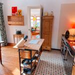 Küche mit Holzwerkzeug, Mosaikboden und Küchenspüle. Durchgang in Wohnzimmer mit Sofa.