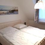 Bedroom with double bed, wall art, and ceiling lamp