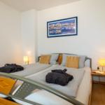 Schlafzimmer mit Doppelbett, zwei Nachttischen und Wandbild.