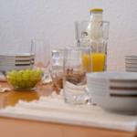 Frühstückstablett mit Gläsern, Schalen und einer Flasche Milch.