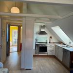 Kitchen with range hood, sink, and dishwasher under sloped roof