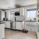 Kitchen with white cabinets, stainless steel appliances, and wooden floor. Windows with view outside.
