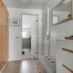 Hallway with closet, mirror, and bench. Passage to kitchen and bathroom.