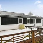House with snow-covered yard, wooden fence, and outdoor table.