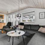 Living room with gray sofa, wooden furniture, and ceiling fan.