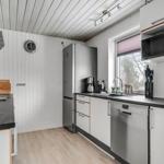 Kitchen with white cabinets, stainless steel appliances, and wooden floor.