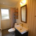 Badezimmer mit Toilette, Waschbecken und Dusche mit Vorhang.