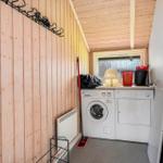 Wäschetrockner und Waschmaschine in einem Raum mit Holzwand und Fenster.