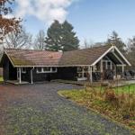 Schwarzes Holzhaus mit Terrasse, Garten und Fußballtor. Gravelweg führt zum Eingang.