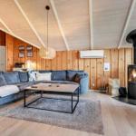 Wohnzimmer mit Sofa, Kamin und Holzwandverkleidung.