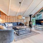 Wohnzimmer mit Sofa, Kamin und Fernseher. Holzwände und hohes Dach.