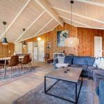 Wohn- und Essbereich mit Holzwänden, Sofa und Tisch. Decke mit Holzbalken.