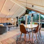 Wohn- und Essbereich mit Holzdecke, Sofa, Esstisch und Blick auf Garten.