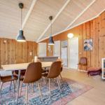 Essbereich mit Tisch, Stühlen und Teppich. Holzwände und Decke. Kunst an der Wand.