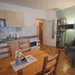 Küche mit Essbereich und Wohnzimmer mit Sofa und Tisch.