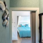 Durchgang in Schlafzimmer mit blauem Bett und Wanddekoration