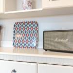 Küchenarbeitsfläche mit Lautsprecher, Servierplatte und Küchenutensilien.