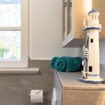 Badezimmer mit Fenster, Handtuch und Leuchtturm-Dekoration
