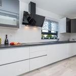 Modern kitchen with stainless steel appliances and dark countertops.