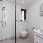 Modern bathroom with shower, toilet, and mirror