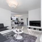 Living room with sofa, TV, and fireplace. Dining area in the background.