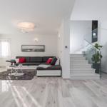 Living room with sofa, staircase, and ceiling light.
