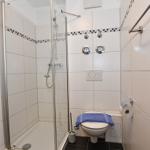 Duschbad mit Dusche, Toilette und Handtuch