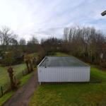 Hinterhof mit Poolhaus, Grillplatz und grünem Rasenbereich.