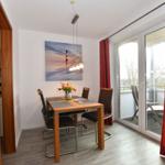 Essbereich mit Tisch, Stühlen und Blick auf Balkon