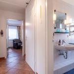 Flur mit Bad und Blick in Wohnbereich mit Sessel.