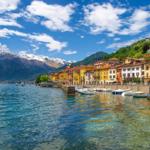Schöne Aussicht auf einen See mit Booten und farbenfrohen Häusern am Ufer.