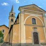 Eine Kirche mit Turm und Eingangstür unter blauem Himmel.