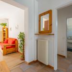 Eingangsbereich mit Spiegel, Heizkörper und Blick in Wohn- und Badezimmer.