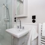 Badezimmer mit Dusche, Waschbecken und Handtuchheizung.