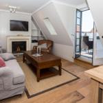 Wohnzimmer mit Kamin, Sofa, Couchtisch und Terrassentür.