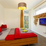 Schlafzimmer mit Doppelbett und Flatscreen TV