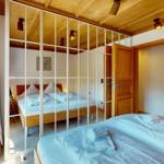 Schlafzimmer mit Spiegelschrank, Holzbett und Holzdecke. Handtuch auf dem Bett.