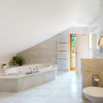 Dusche, Badewanne und Toilette in einem hellen Badezimmer mit Dachschrägen.