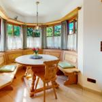 Rundtisch mit Holzbank und Fensterblick in rustikalem Stil.
