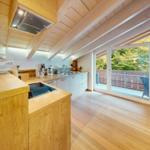 Küche mit Holzdecke und Balkonanschluss. Moderne Einrichtung und hellen Holzboden.