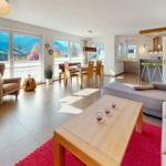 Wohn- und Essbereich mit Balkonblick, Küche und Schlafzimmer im Hintergrund.