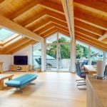 Großer Wohn- und Essbereich mit Holzdecke, großen Fenstern und Terrasse.