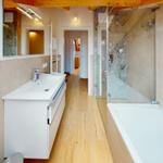 Badezimmer mit Dusche, Badewanne und Waschbecken mit Spiegel.