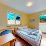 Ein Schlafzimmer mit Doppelbett, Schreibtisch und Blick auf die Berge.