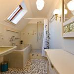 Badezimmer mit Dusche, Badewanne, Waschbecken und Spiegel