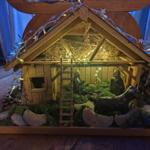 Weihnachtsdekoration: Handgetöpferte Krippe unterechtem Baum